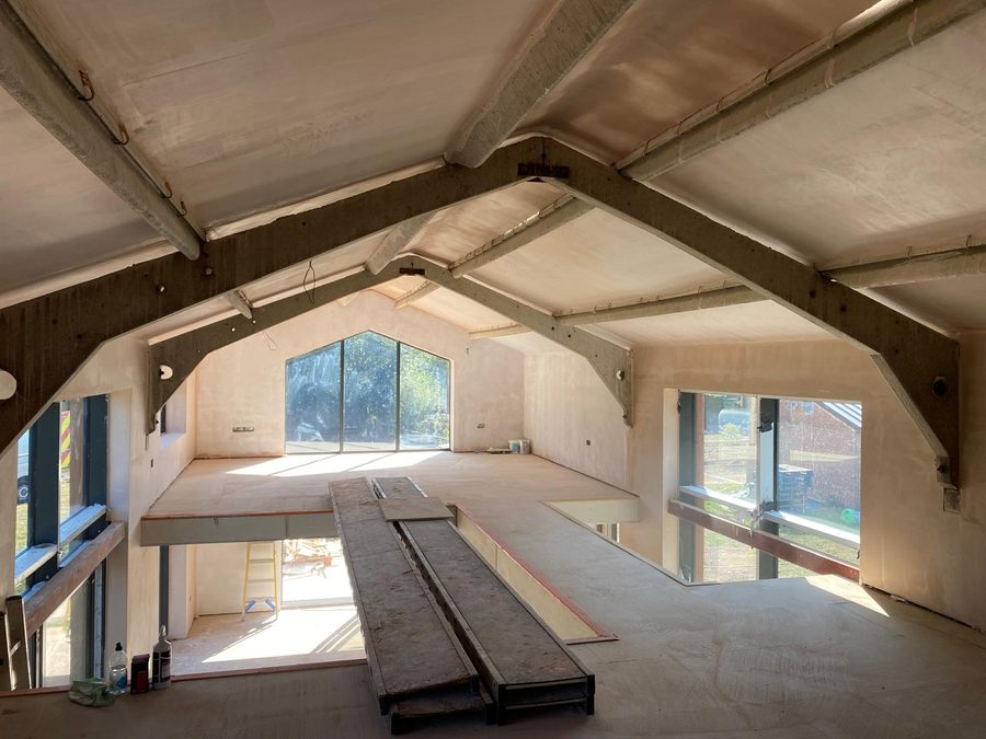 Large vaulted room freshly skimmed, exposed steel beams left visible