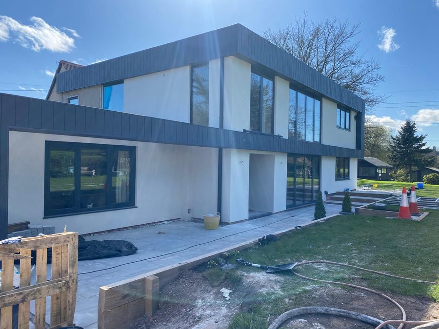 Contemporary two-storey new build with white render and dark cladding